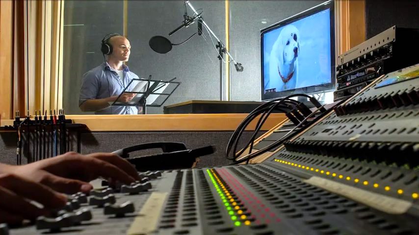 ADR Voice Over Jobs. Image of young man in a voice over recording studio recording a ADR session with a sound engineer. This image is used to illustrate the article "ADR Voice Over Jobs: An Exciting Career Path".