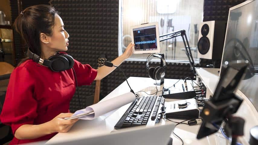 Internet voice over jobs. Image of a woman working with professional radio equipment. This image is used to illustrate the article "The Rise of Internet Voice Over Jobs." Freepik license: https://www.freepik.com/free-photo/woman-working-with-professional-radio-equipment_11937746.htm