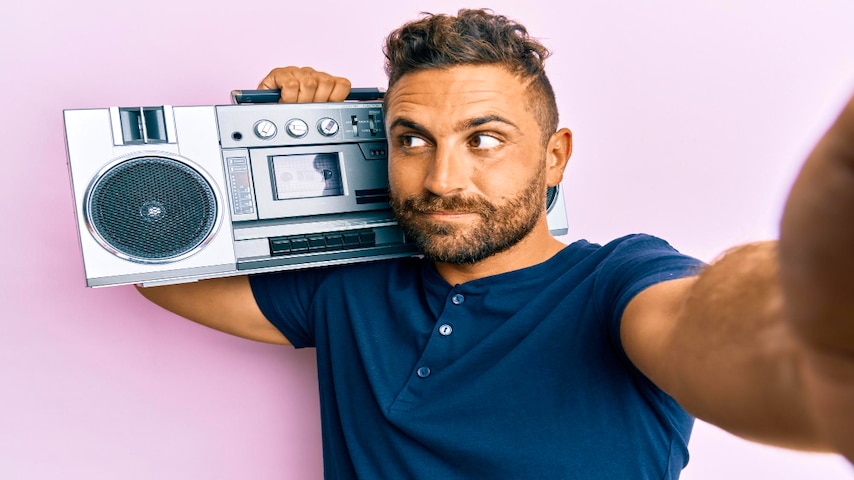 Radio Voice Over Jobs. Image of a handsome man with beard holding boombox listening to music smiling looking to the side and staring away thinking. This image is used to illustrate the article "Radio Voice Over Jobs: Amplify Your Career." Freepik license: https://www.freepik.com/free-photo/handsome-man-with-beard-holding-boombox-listening-music-smiling-looking-side-staring-away-thinking_39393108.htm