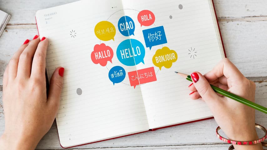 What is Localization and Why is it Key in Video Production? Woman writing hello in different languages over a notebook. Picture by Tridindia at Pixabay. Pixabay License. https://pixabay.com/es/photos/lenguaje-diferente-internacional-7389469/