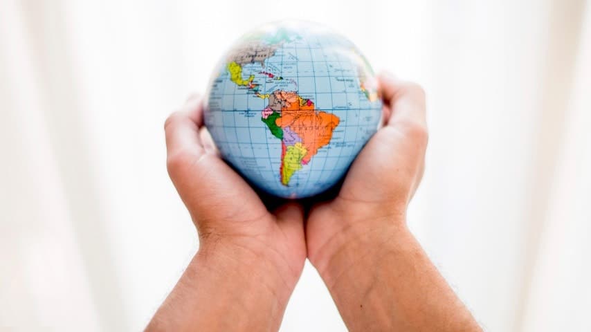 Linguistic Diversity. Image of a person's hand holding a small globe. This image is used to illustrate the article "Celebrating Linguistic Diversity." Freepik licence: https://www.freepik.com/free-photo/person-s-hand-holding-small-globe_3143216.htm